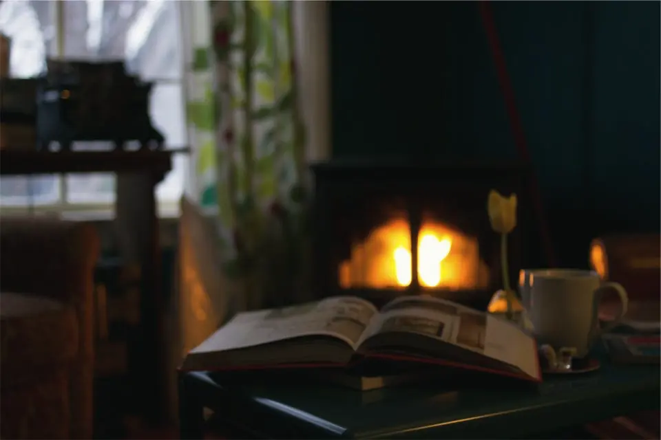 Камината в Хижата вечер, книга и чай